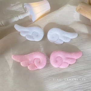 Detailansicht der weichen Plüsch-Engelsflügel Haarklammern in Weiß und Rosa