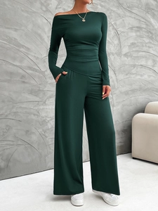 Detailed view of dark green two-piece set featuring off-shoulder top and wide-leg trousers