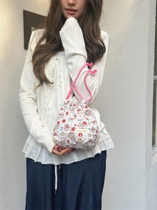 Quilted cartoon bucket bag with pink drawstring handles shown on a female model
