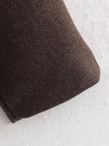 Detailed close-up showing texture of dark brown wool fabric for an oversized coat