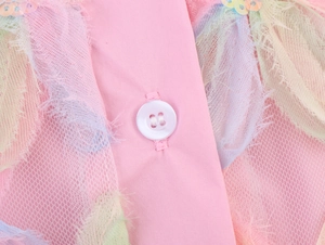 Macro detail of pastel rainbow mesh blouse with white button and textured embroidery