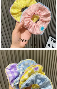 Close-up of colorful checkered fabric scrunchies in pink, yellow and blue candy tones