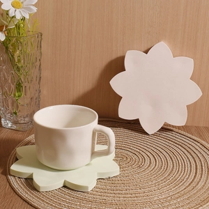 Elegant lotus petal coaster with cream ceramic mug on a woven placemat for home decor