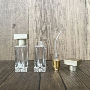 Detailed view of square glass perfume bottles with golden spray nozzles and caps