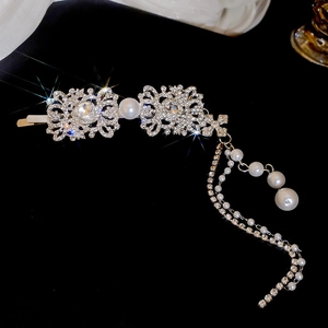 Detail of square hair clip with rhinestones, pearls and elegant dangling tassels