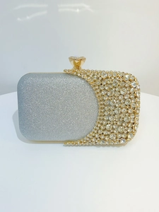 Macro detail of luxury evening clutch with silver glitter fabric and crystal encrusted frame