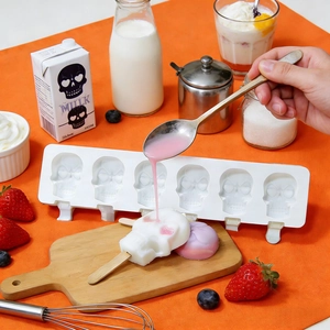Moule à glace en silicone à 6 cavités en forme de crâne avec bâtonnets sur fond orange