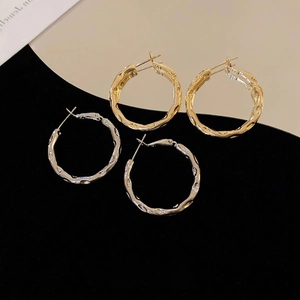 Minimalist hammered gold and silver geometric hoop earrings with rippled texture finish