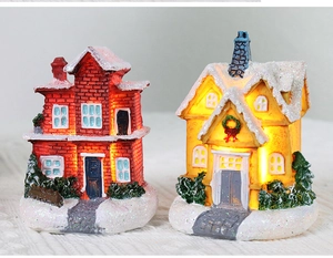 Detail of Christmas resin house ornaments with snowy finish and warm LED light