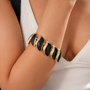Gros plan du bracelet feuille dorée vintage avec émail noir et texture en métal brossé