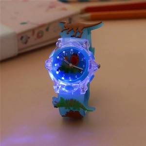 Close-up of luminous kids watch with blue silicone strap and 3D cartoon dinosaur patterns