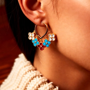 Macro view of vintage 18K gold plated flower fringe earrings with turquoise and red stones