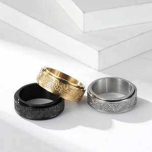 Detailed view of rotating spinner rings in black, gold, and silver with Celtic knot design