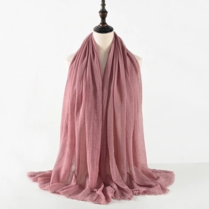 Detail showing the pleated texture and soft frayed edges of the dusty pink linen scarf