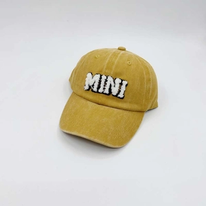 Close-up of yellow washed cotton baseball cap featuring high-quality MINI embroidery