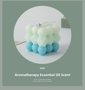 Macro detail of geometric stacked candle with green gradient layers and For You ribbon