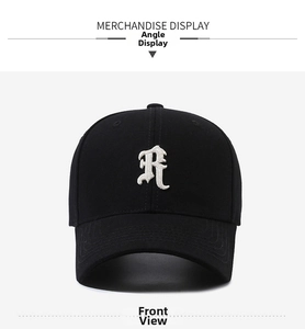 Detail of white gothic R embroidery on black cotton twill baseball cap with curved brim