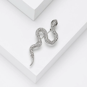 Detailed view of a silver snake brooch featuring sparkling rhinestones on geometric stand