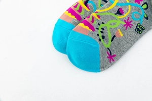 Close-up of gray cotton knitted socks with blue toe and colorful floral patterns