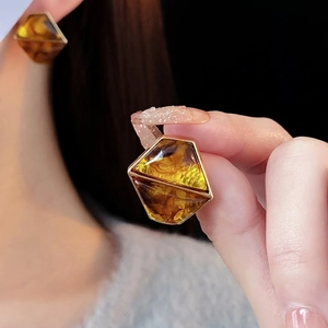 Vintage amber resin geometric stud earrings with gold trim worn on ear