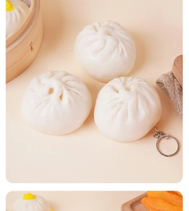 Macro detail of three realistic PVC steamed bun keychains on a rustic bamboo steamer base