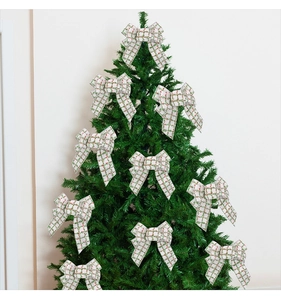 Close-up of nine white and green plaid Christmas bows hanging on a festive green tree