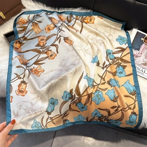 Detail eines Seidenschals mit Blumenprint, blau-orangefarbenem Verlauf und Maiglöckchen