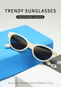 Close-up of beige cat-eye sunglasses placed on geometric props for trendy summer fashion