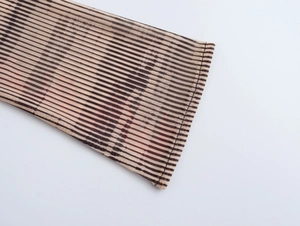 Gros plan sur le tissu en maille rayée marron avec coutures fines sur l'ourlet et le poignet