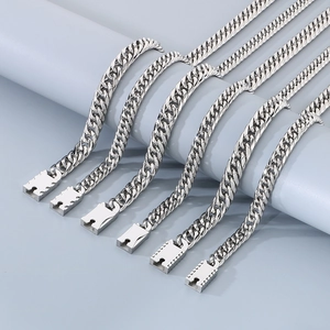 Detailed view of silver Cuban link chains with polished box clasps on a grey studio setup
