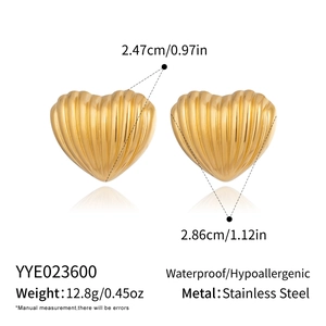 Detail view of gold heart earrings showing textured finish and product specifications