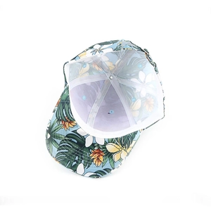 Detail view of tropical floral print baseball cap with palm leaves and hibiscus flowers