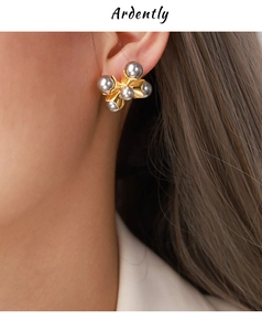 Detail of elegant gold earrings with grey pearls on model showing sophisticated French style