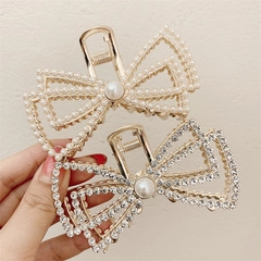 Detail showing gold pearl and silver rhinestone butterfly hair clips for women