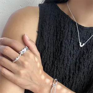 Close-up of minimalist 925 sterling silver V-necklace with matching rings and bracelet