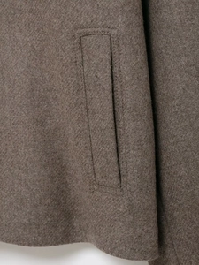 Makroaufnahme von braunem Wollmischgewebe und professionellen Paspeltaschen-Details