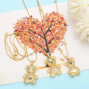Detailed macro view of gold-plated bear necklaces with inlaid zircon and heart-shaped gems