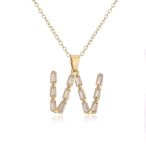 Detailed view of 18K gold plated letter W pendant necklace set with baguette cubic zirconia