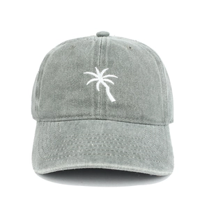 Close-up of coconut tree embroidery and washed grey fabric texture on baseball cap
