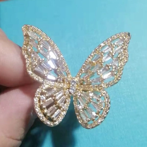 Macro detail of golden butterfly ring with sparkling zircons and hollow wing design