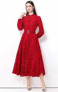 Détail d'une robe en dentelle rouge avec col montant, manches lanternes et ceinture assortie