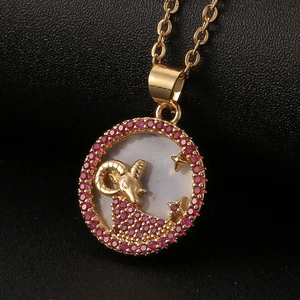 Macro detail of Aries zodiac necklace featuring white mother of pearl and red gemstones