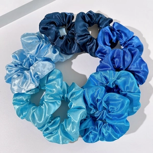 Detailed view of assorted blue satin scrunchies with silky texture and elegant shine