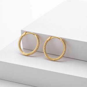 Détail de boucles d'oreilles créoles dorées en argent S925 serties de zircons cubiques
