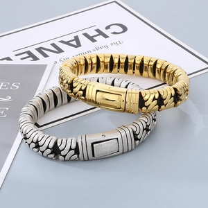 Detail of vintage textured metal clasps on gold and silver titanium steel bracelets