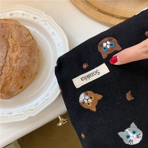 Detail of black cotton linen pouch featuring cute cat embroidery and Sozakka woven label