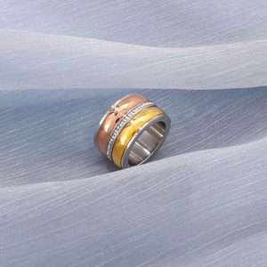 Macro shot of three-tone stainless steel band ring with embedded pavé zircons