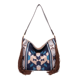 Detail of bohemian tote bag featuring geometric tribal patterns and long side tassels