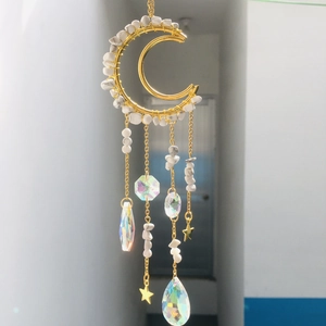 Detail of golden moon suncatcher with amethyst stones and crystal prism pendant