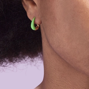 Close-up of bright green enamel croissant hoop earrings in gold-plated silver
